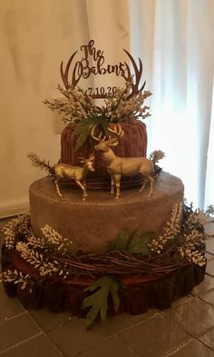 a three tiered cake decorated with deer and flowers