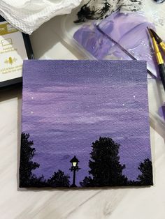 an acrylic painting of trees and a street light in the distance with purple hues