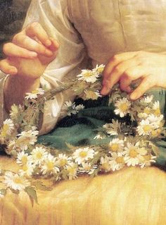 a close up of a person with flowers in their hands on a cloth and fabric