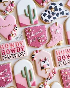 decorated cookies with pink and white frosting are arranged on a table top in the shape of cactuses