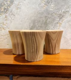 three wooden cups sitting on top of a table