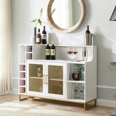 a white cabinet with wine bottles and glasses on it in front of a round mirror