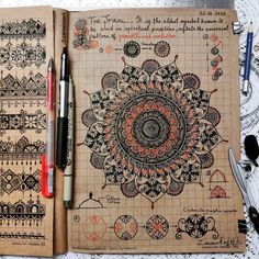 an open notebook with drawings on it and two pens sitting next to each other in front of the pages