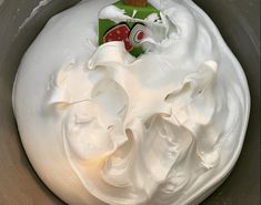 whipped cream in a mixing bowl with a whisk on the side and a bottle of toothpaste next to it