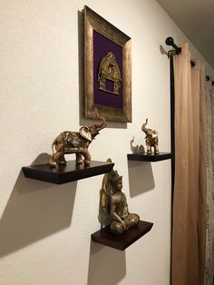 three shelves with figurines on them in front of a painting and shower curtain