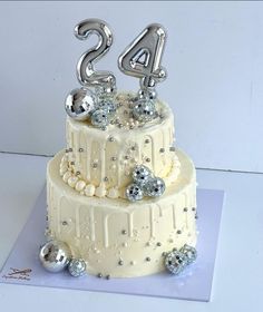 a white cake with silver decorations and numbers on top