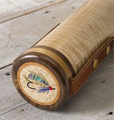 a close up of a wooden object on a floor with wood grain and leather trim