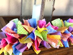 a bunch of colorful pinwheels sitting on top of a table next to a candle