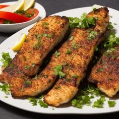 three fish fillets on a white plate with garnishes