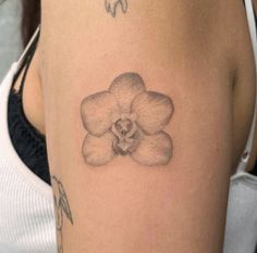 a woman with a tattoo on her arm has a flower in the shape of a heart