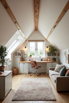 a room with a couch, desk and chair under a slanted ceiling that has wooden beams