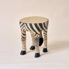 a zebra stool made out of wood with black rubber boots on it's legs