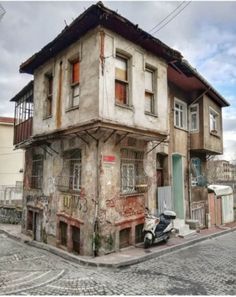 an old run down building with graffiti on it's side in the middle of a cobblestone street