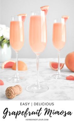 three glasses filled with grapefruit mimosa sitting on top of a table