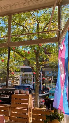 an outdoor cafe with wooden benches and flags