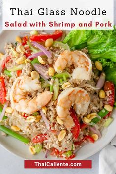 a white plate topped with rice, shrimp and veggies next to lettuce