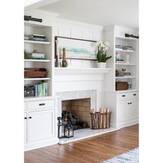 a living room with white cabinets and a fireplace