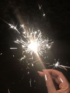 someone holding a sparkler in their hand at night