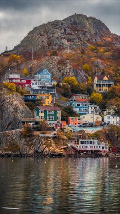 the houses on the hill are all painted in different colors and sizes, along with their own dock