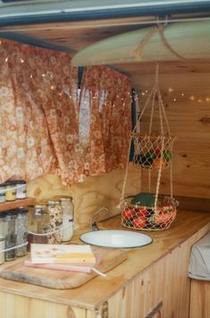 the inside of a camper with curtains and food on the counter in front of it