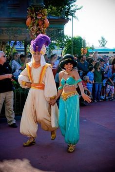 two people dressed in costumes walking down the street