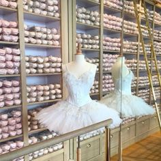 two mannequins dressed in white tutues and dresses are on display