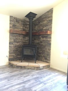 an empty room with a wood stove in the corner