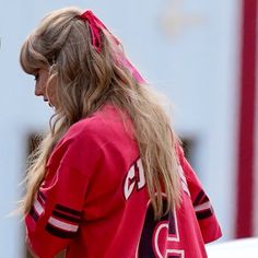 a woman in a red jersey holding a cell phone