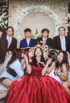 a group of young people posing for a photo in front of a backdrop with flowers