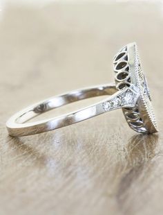 a diamond ring sitting on top of a wooden table