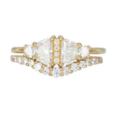 three stone engagement ring set in yellow gold with white diamonds on the sides and side stones