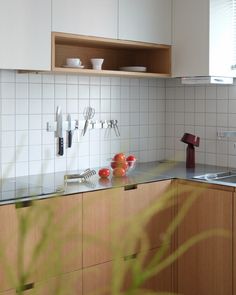 a kitchen with white tiles and wooden cabinets