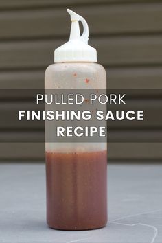 a bottle filled with sauce sitting on top of a table next to a building and the words pulled pork finishing sauce recipe