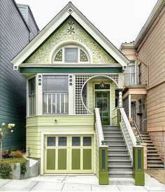 a green and white house with stairs leading up to it