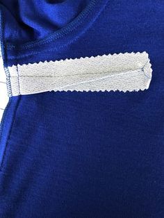 a close up of a blue shirt with white stitching on the front and side