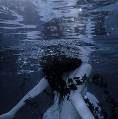 a woman is floating in the water with her head above the water's surface