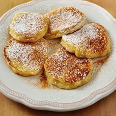 powdered sugar covered pastries on a white plate