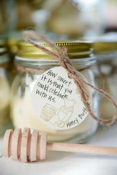 a jar filled with honey and a wooden spoon sitting next to it on top of a table