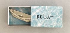 an open box with a paper boat in the water on it's side that says float