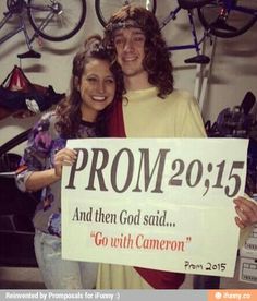 a man and woman standing next to each other holding a sign that says prom 2013