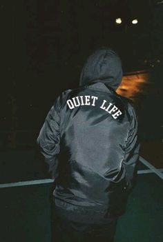 a person wearing a black jacket with the words quiet life on it's back