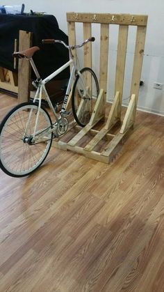 a bicycle is parked on a wooden pallet in a living room with hard wood flooring