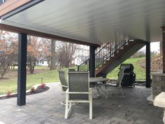 a covered patio area with chairs and tables