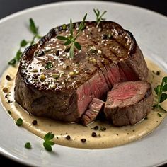 a piece of steak on a plate with sauce and garnish