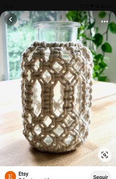 a crocheted vase sitting on top of a wooden table