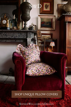 a red chair sitting in front of a fire place