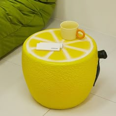 a lemon shaped stool with a cup on top and a name tag attached to it