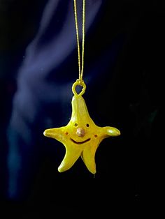 a yellow starfish ornament with a smiley face hanging from it's side