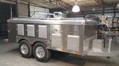 a silver food truck parked inside of a garage next to a light bulb hanging from the ceiling