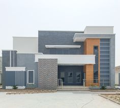 a large gray and white building with a clock on it's front door in the middle of an empty parking lot